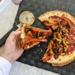 mexican tortilla pizza recipe - me holding a slice of pizza