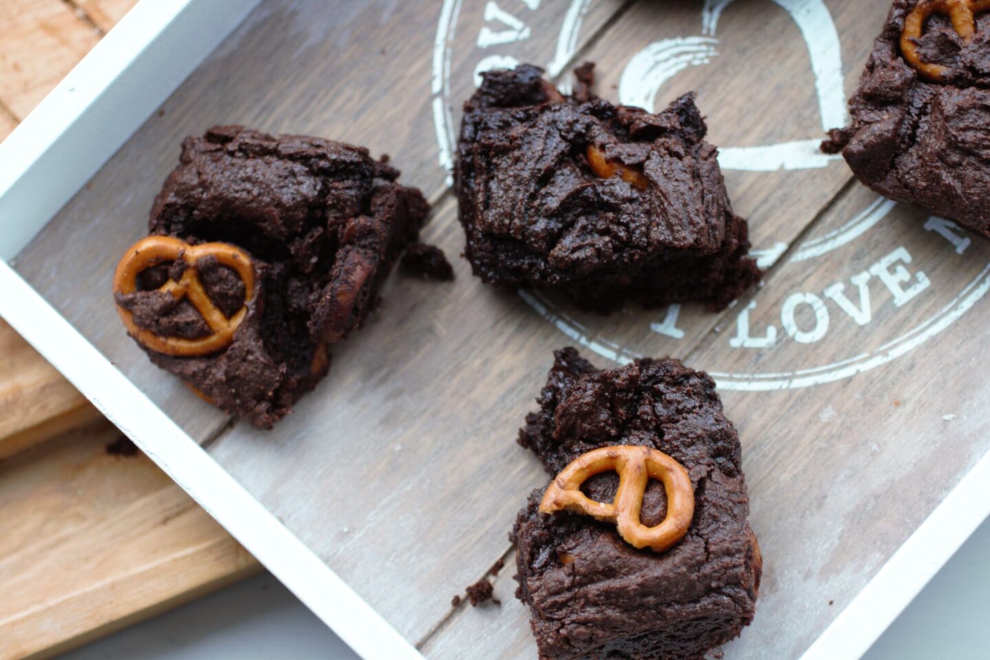 some peanut butter pretzel brownies recipe on a grey wooden tray