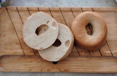 a wooden tray with two gluten free bagels placed on it