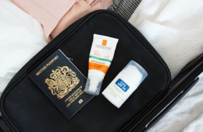 covid travel checklist - a packed suitcase with a passport and SPF on top