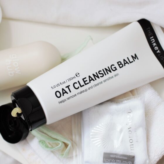 the inkey list oat cleansing balm tube, shot from above with some cloths placed next to it
