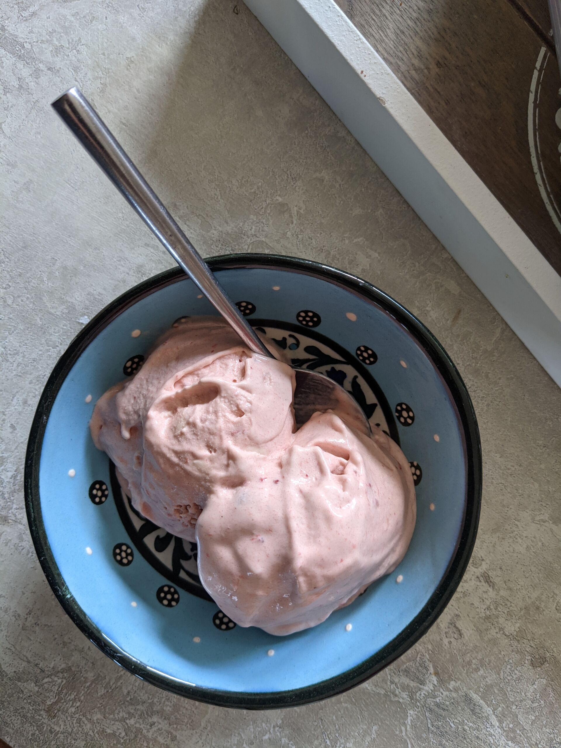 small bowl with two scoops of strawberry ice cream recipe in it