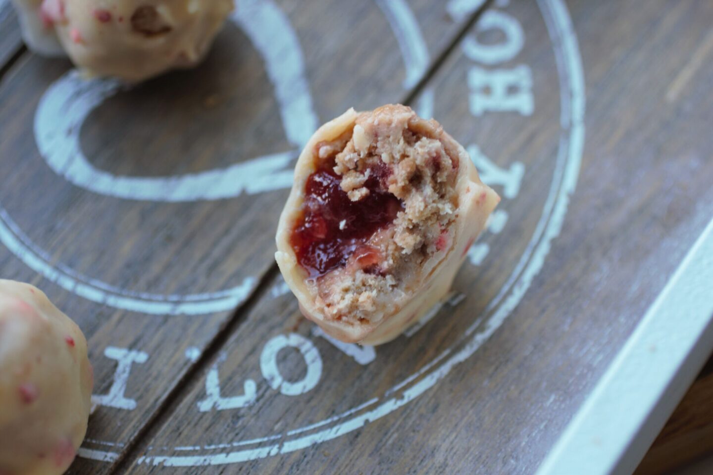 a close up of the centre of one of the strawberry white chocolate cheesecake bites to show the texture in the centre