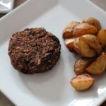 a cranberry & quinoa Christmas Bake on a white plate with some roast potatoes
