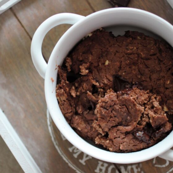 a bowl of mint chocolate baked oats on a grey wooden tray