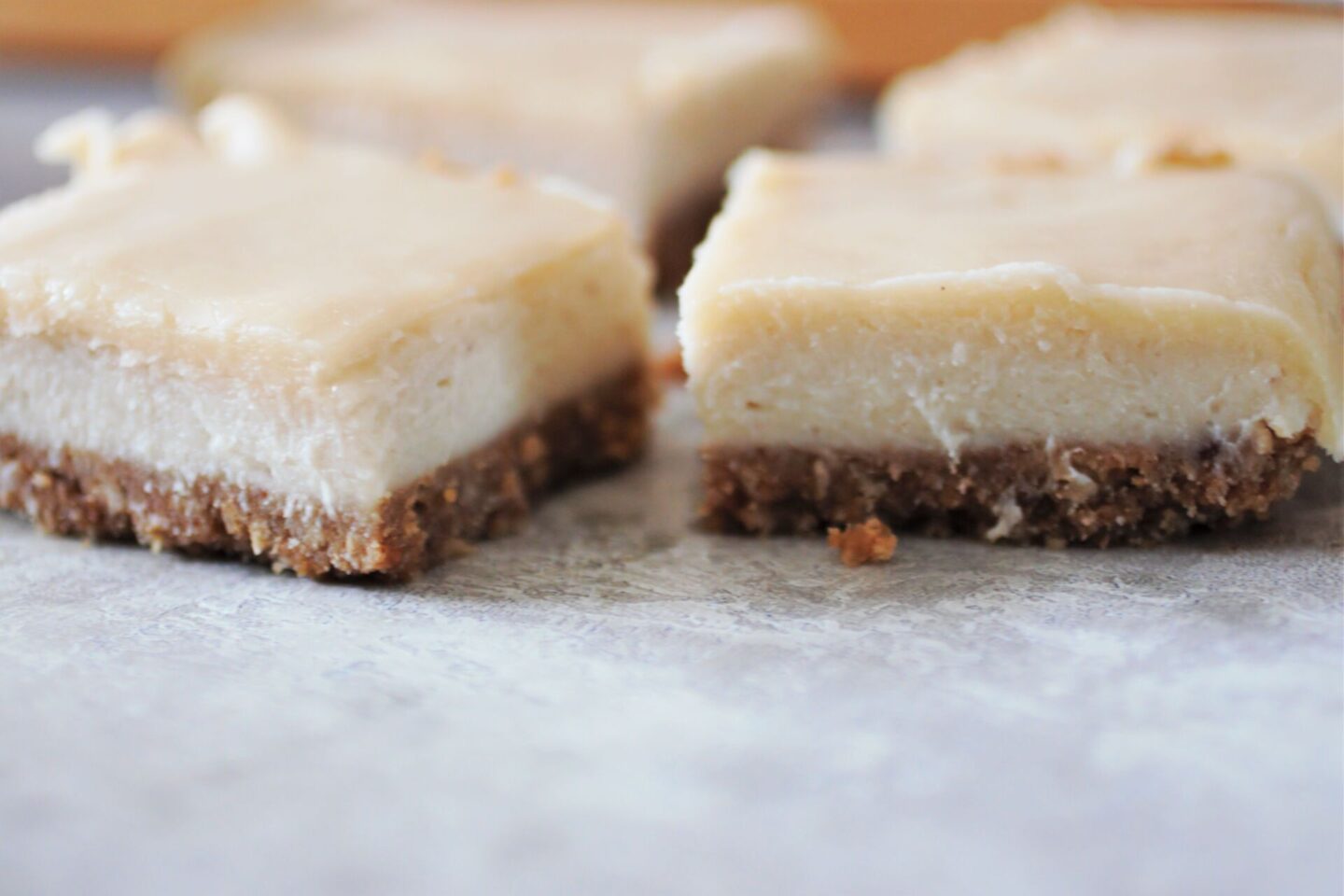 two slices of white chocolate cheesecake, shot from the side to show layers