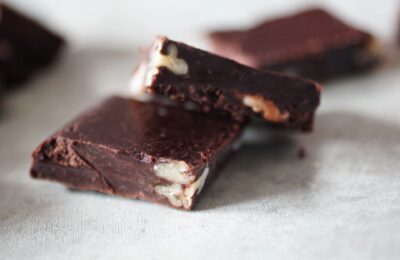 two squares of avocado fudge chocolates chopped to show the nuts inside