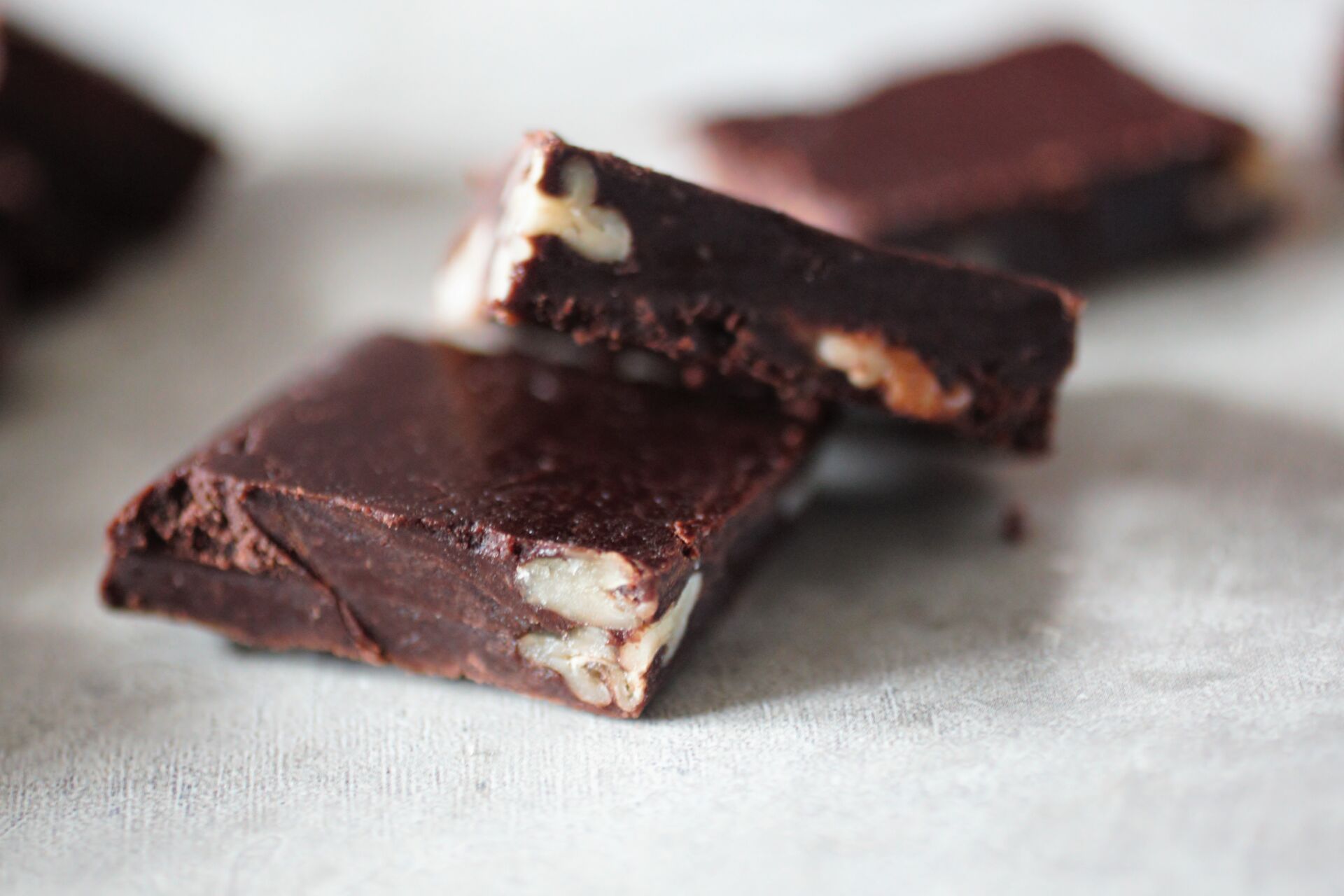 two squares of avocado fudge chocolates chopped to show the nuts inside