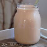 pineapple smoothie recipe in a glass kilner jar against a white wall