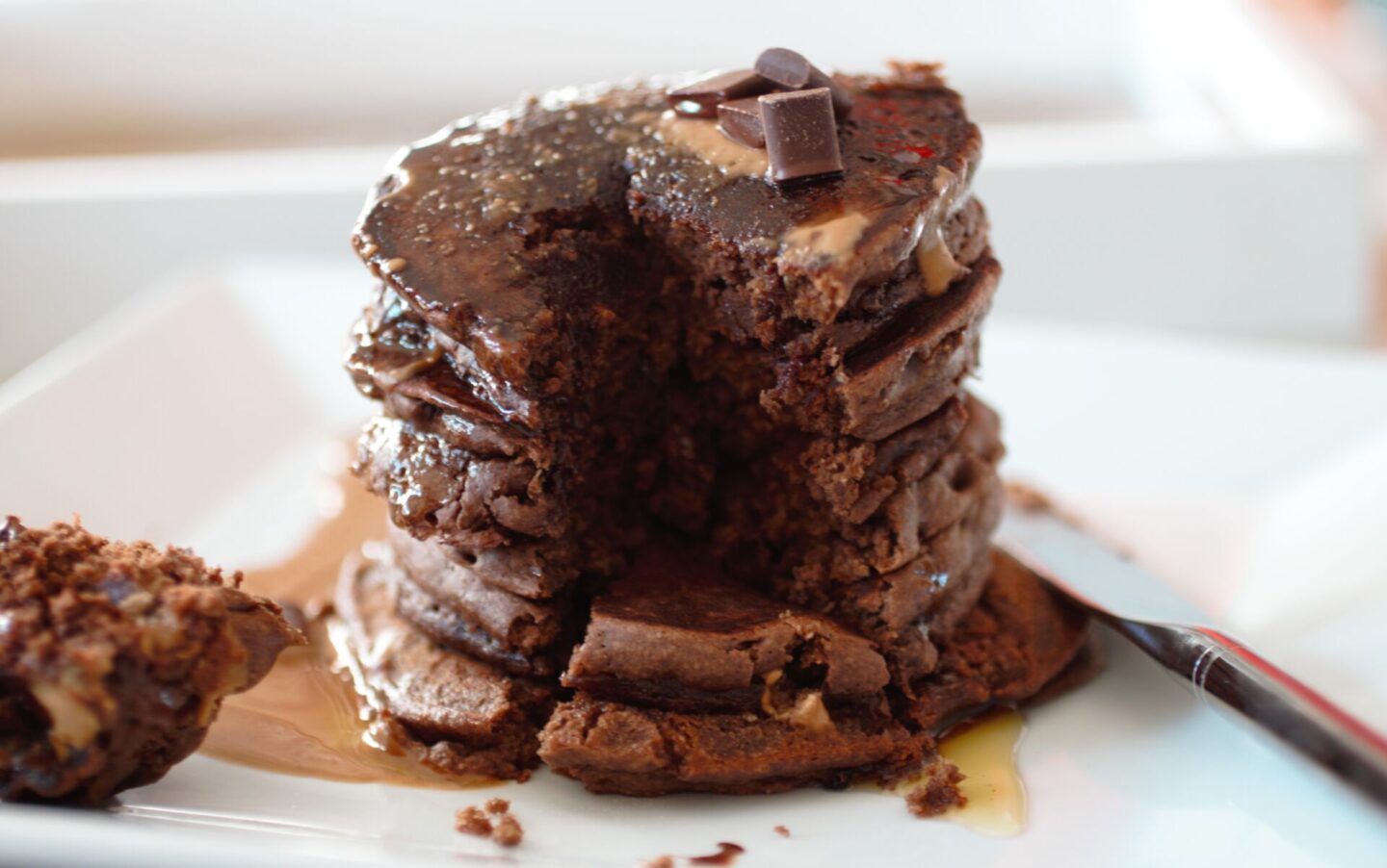peanut chocolate pancakes recipe stacked with a piece cut out
