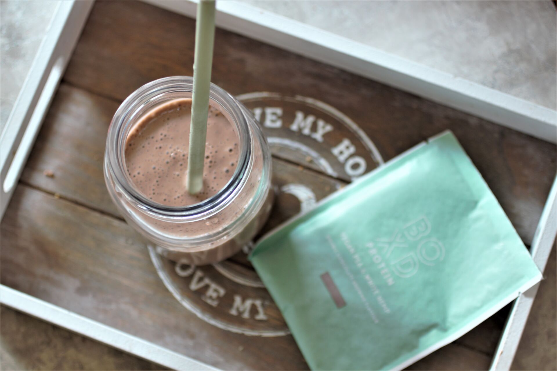 boxd protein review - a sachet of chocolate protein on a tray with a chocolate shake