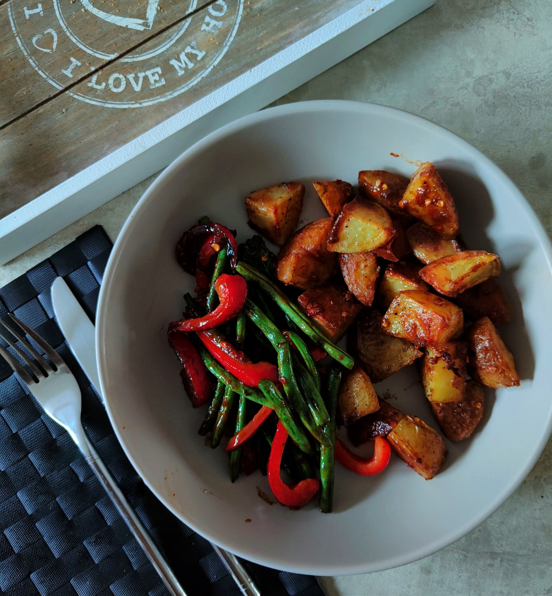 a bowl of almond butter roast potatoes recipe with green beans and red peppers, shot from above