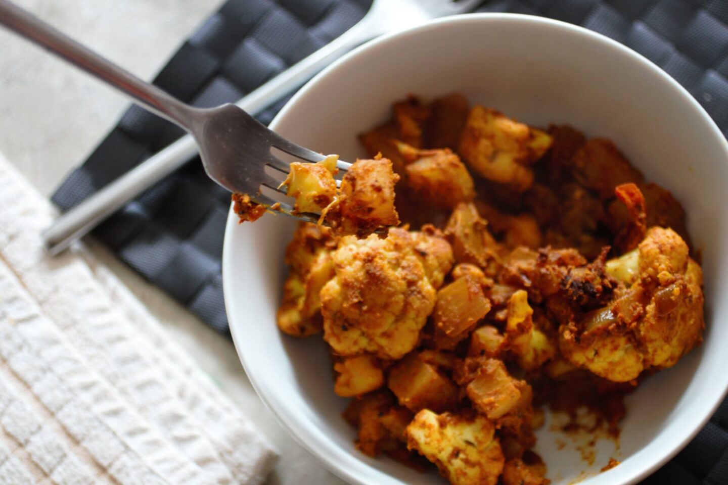 bowl of aloo gobi with a fork in it