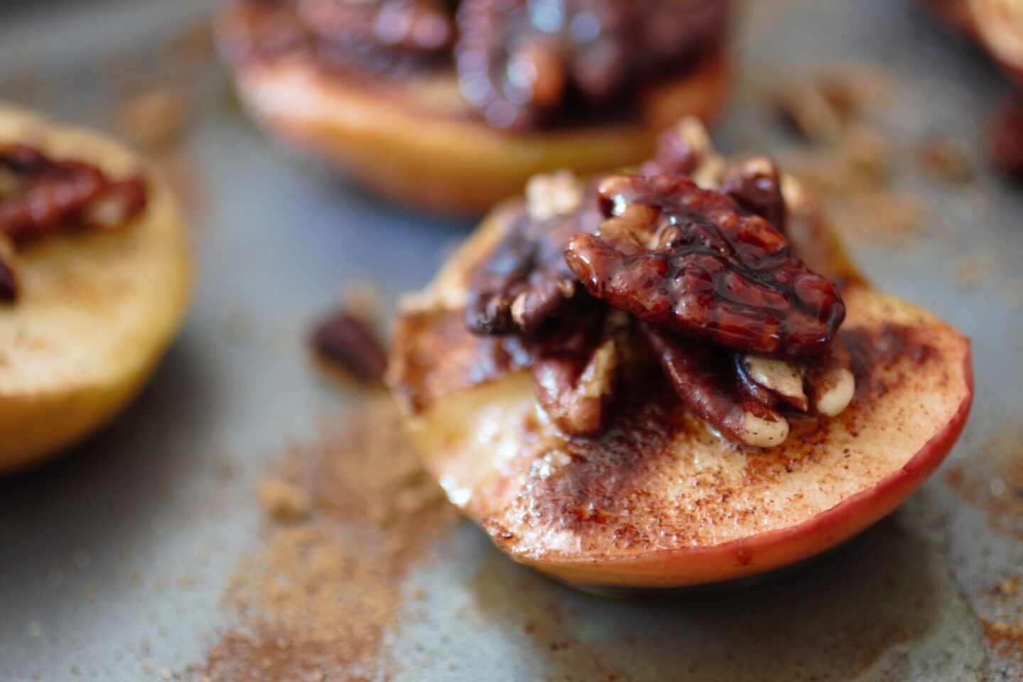 spiced pecan baked apples, close up of one apple with candied pecans on top