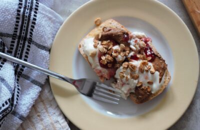baked breakfast ciabatta topped with yoghurt and nut butter, shot from above