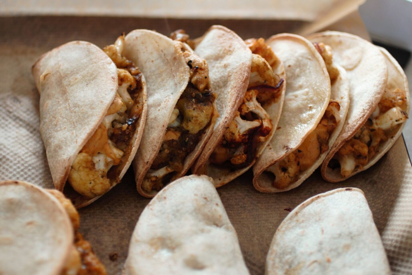 row of cauliflower tacos stacked next to each other