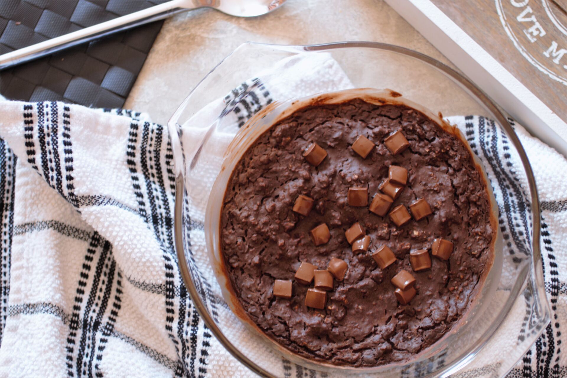 freshly baked chocolate cheesecake baked oats, placed on a tea towel, shot from above