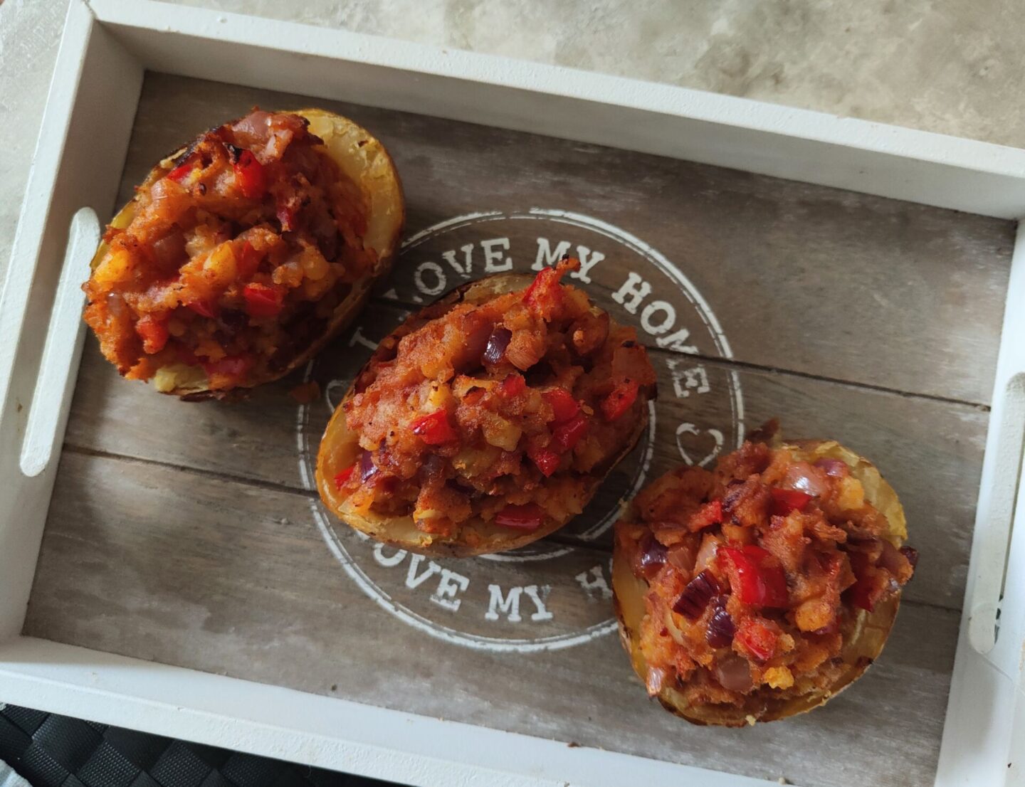 tray with three stuffed harissa jacket potatoes on it
