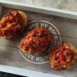 tray with three stuffed harissa jacket potatoes on it
