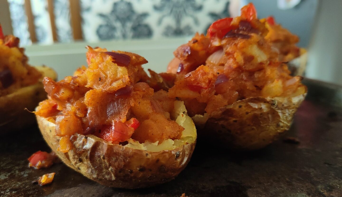 baking tray with freshly baked harissa jacket potatoes on it