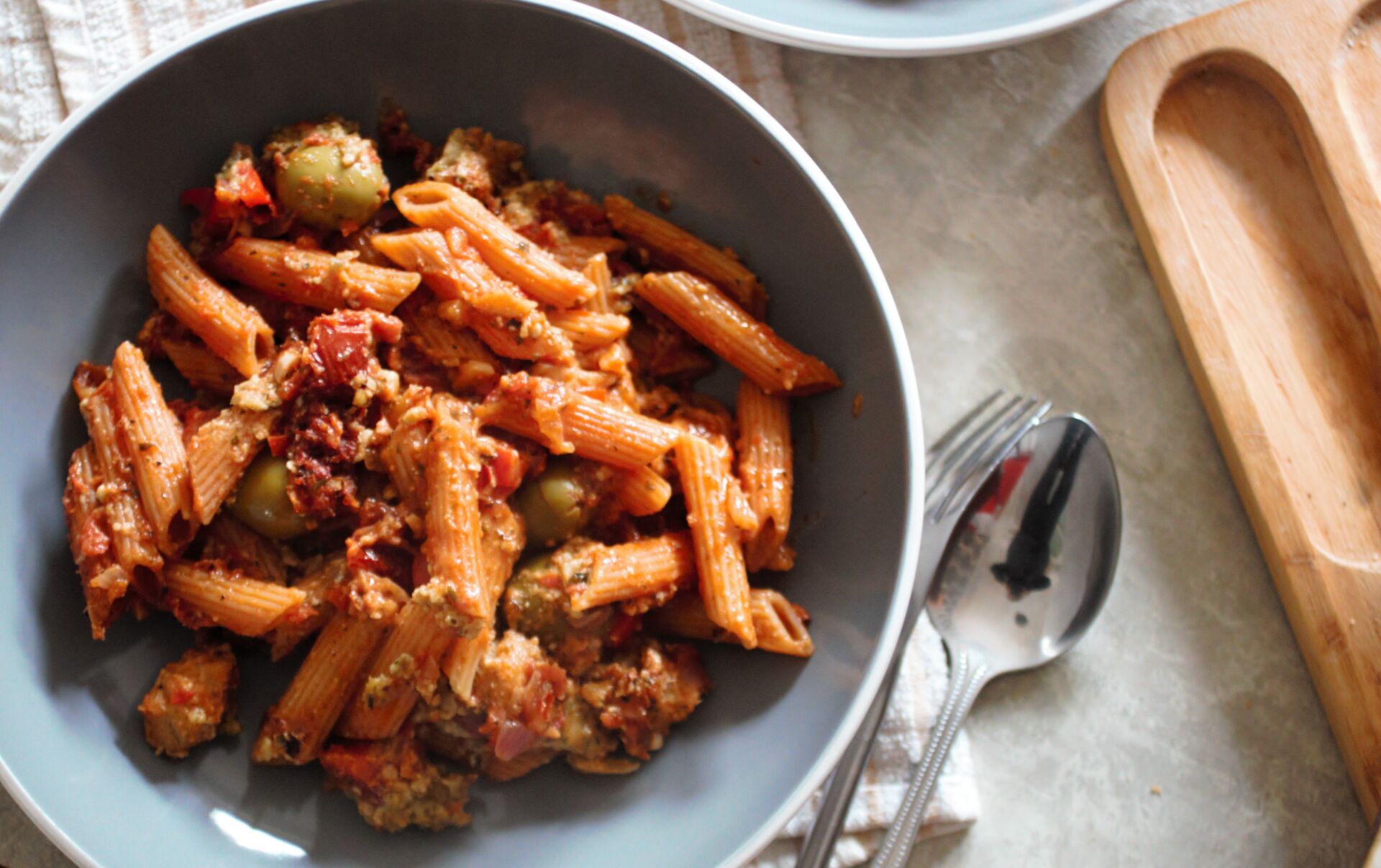 a bowl of sundried tomato pasta bake recipe placed on a table, shot from above