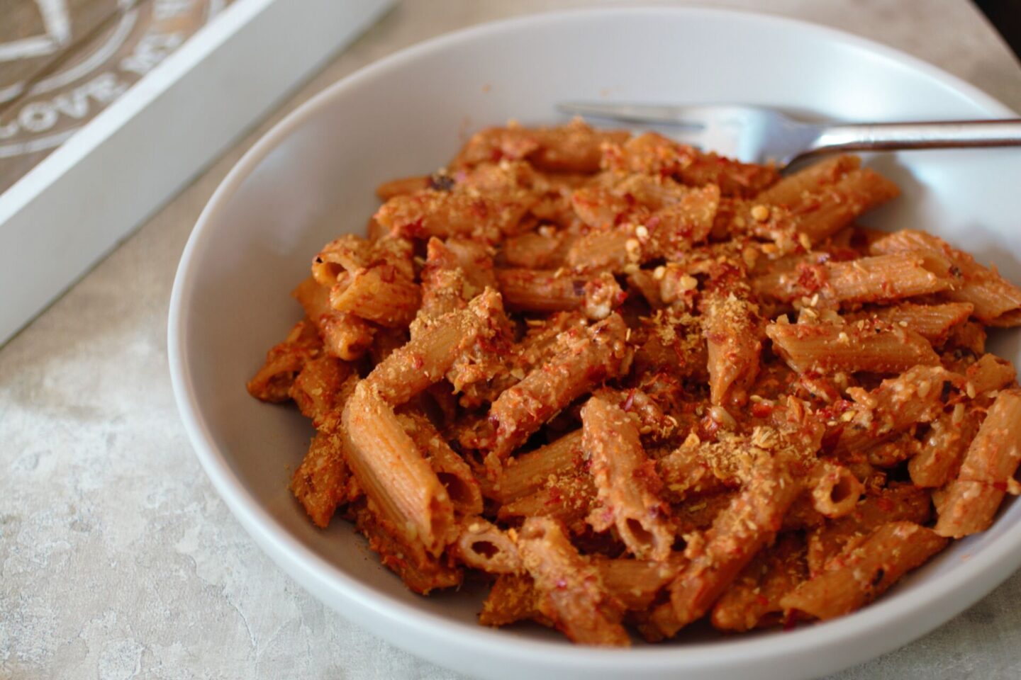 a bowl of red pepper pesto pasta