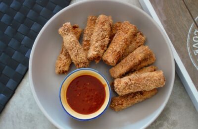 a bowl of tofu fingers with a pot of dip