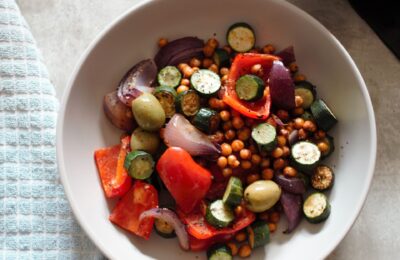 a bow of mediterranean vegetable tray bake, without the sauce, shot from above