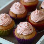 a wooden tray with six strawberry cupcakes on it
