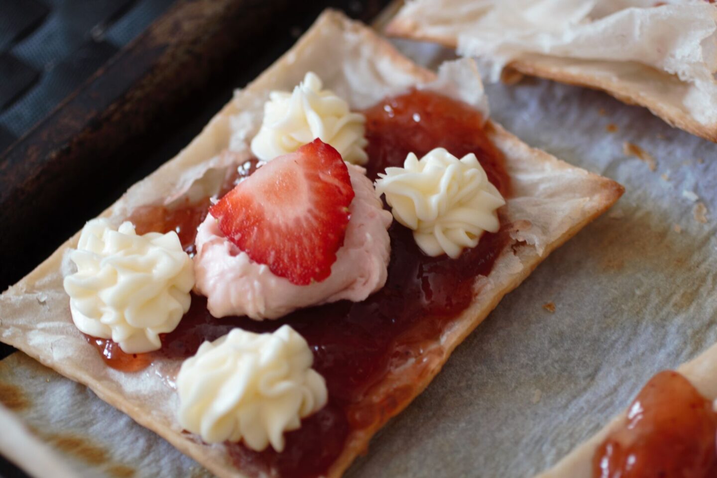 a strawberry cream puff filled with buttercream and strawberry frosting