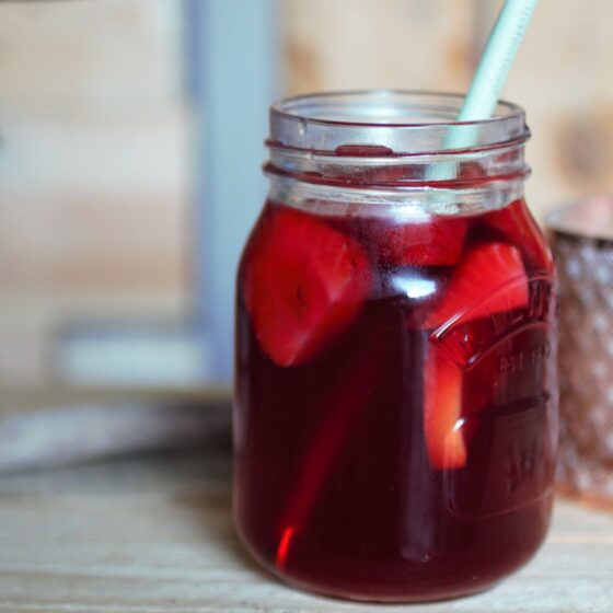 strawberry gin punch in a kilner jar against a wooden background