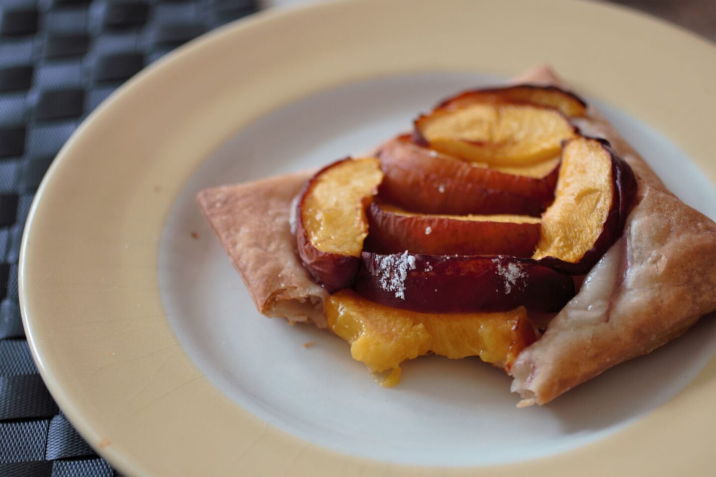 vegan peach tart recipe - a tart on a plate with a bite taken to show the texture