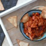 tray with pot of pumpkin chilli dip and homemade tortilla chips