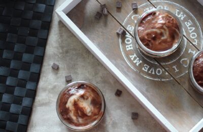 vegan mint chocolate cheesecakes on a table, with some chocolate chips scattered around them.