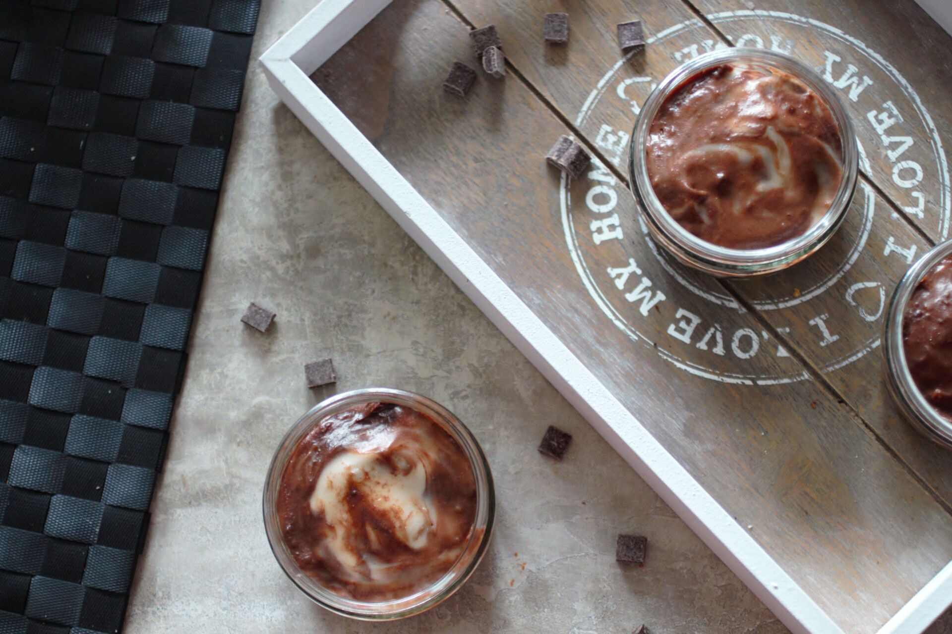vegan mint chocolate cheesecakes on a table, with some chocolate chips scattered around them.