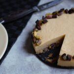 orange pistachio tart recipe with a slice taken out and a knife next to it