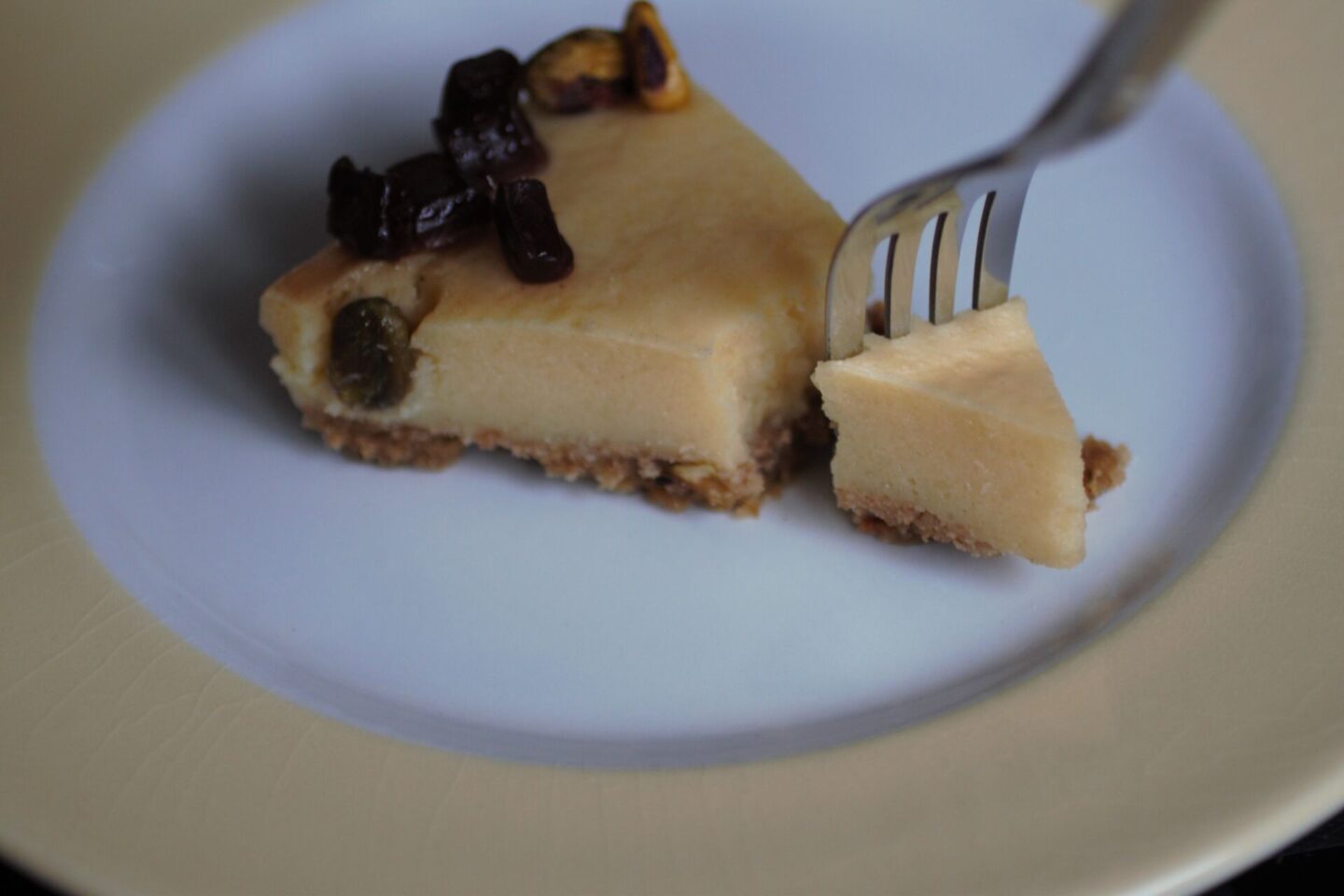 a slice of orange pistachio tart recipe on a plate with a fork taking a section away