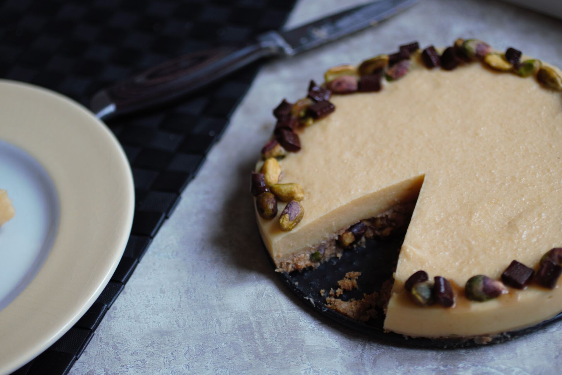orange pistachio tart recipe with a slice taken out and a knife next to it