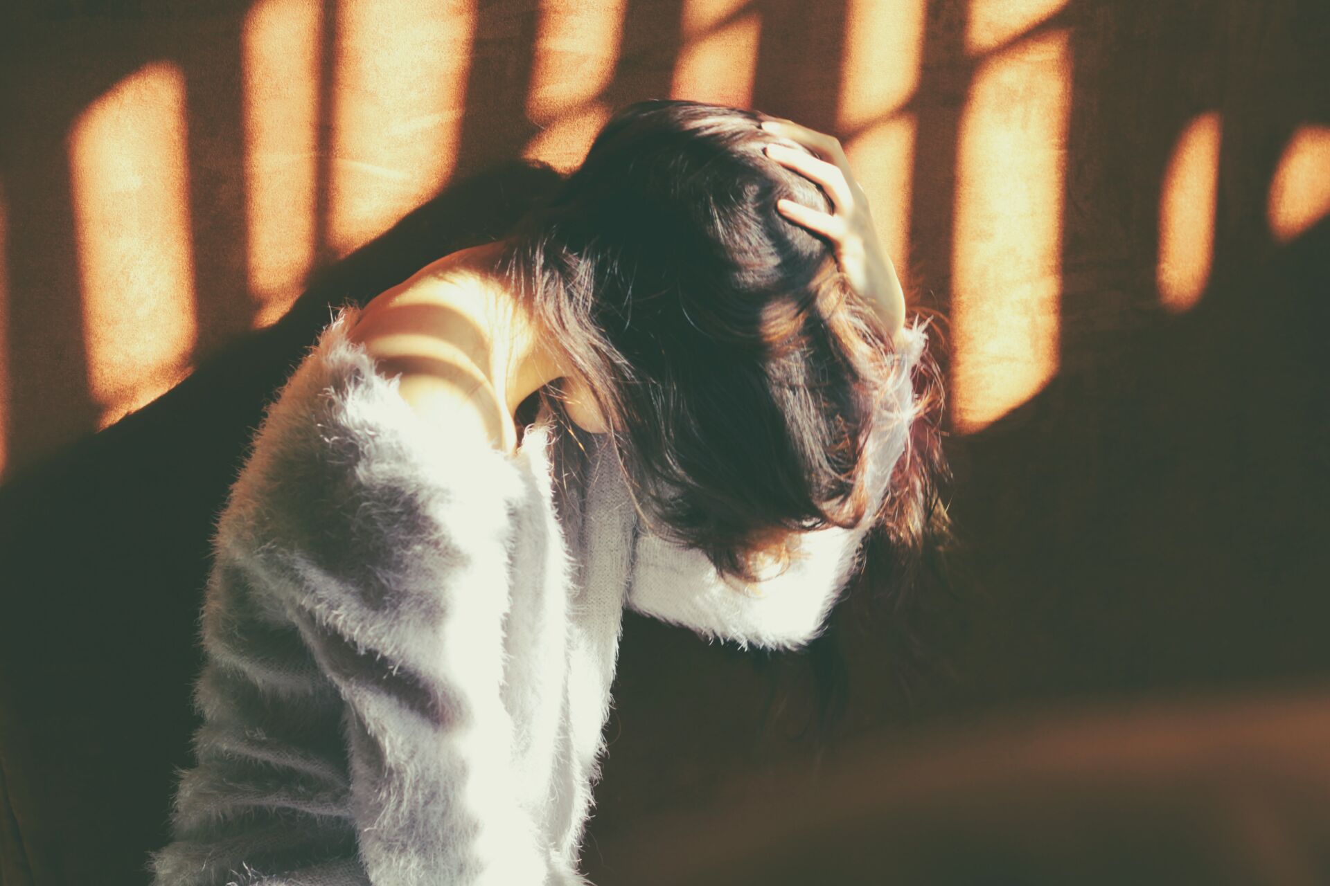 ways to manage migraines - woman holding her head against a wall