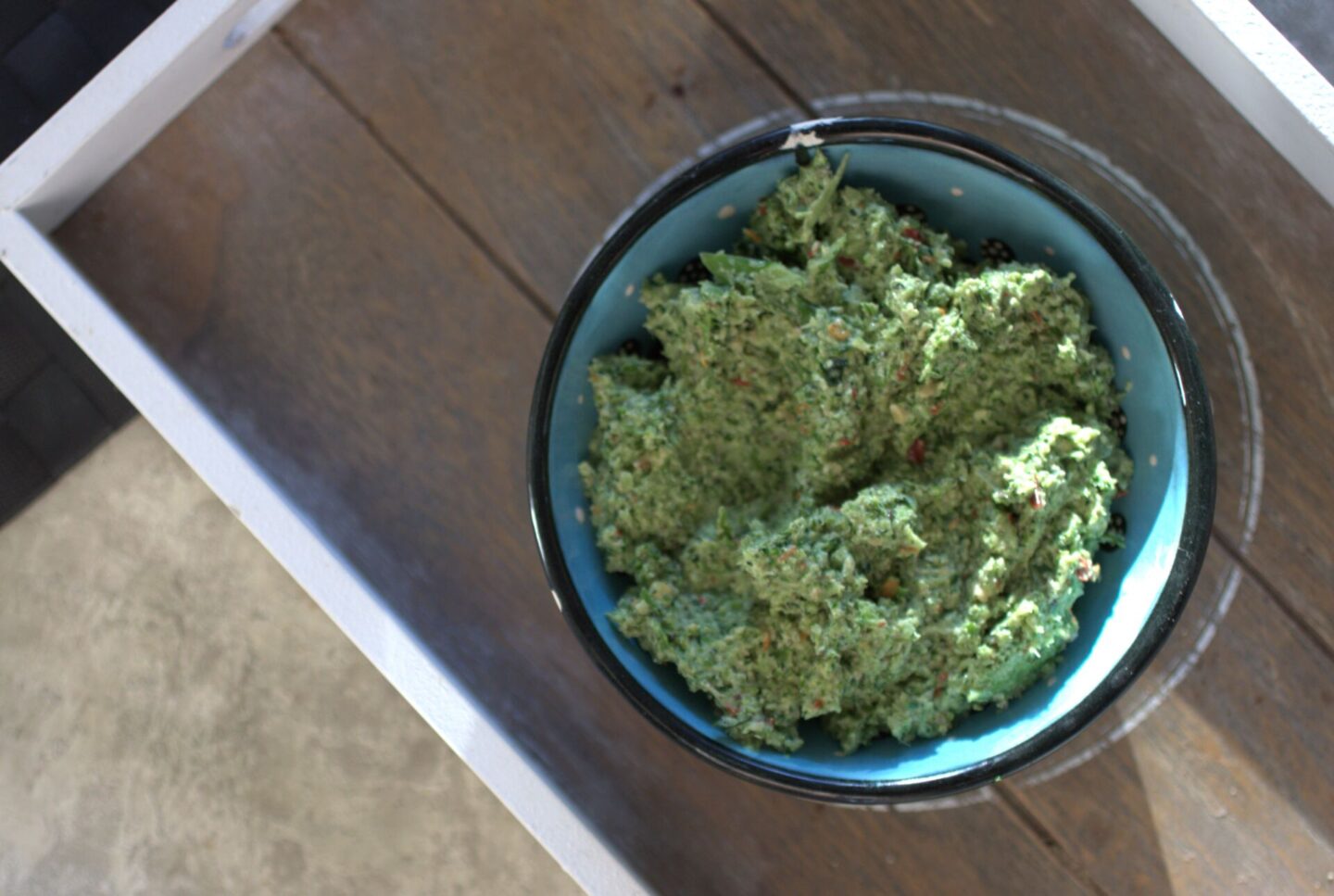 a pot of broccoli & lime pesto recipe placed on a grey wooden tray