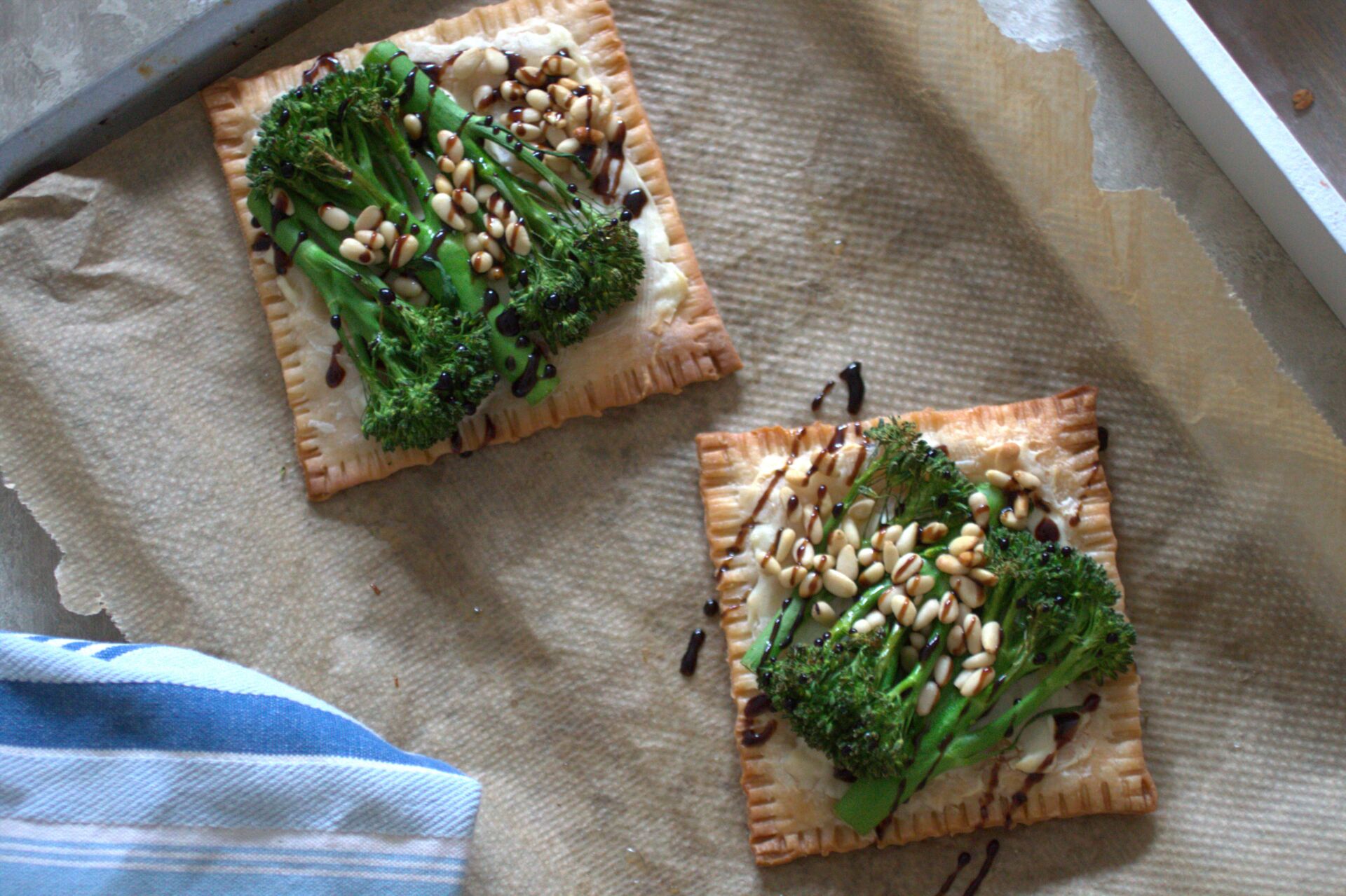 two freshly cooked broccoli tarts on a baking sheet