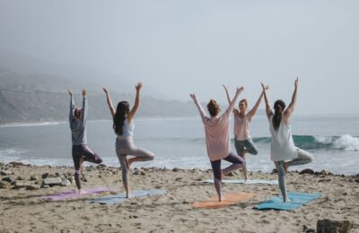 Tips to help you handle hot flashes - women on a beach doing yoga
