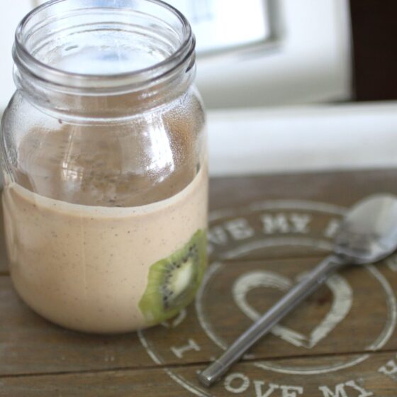 kiwi breakfast pudding in a kilner jar, on a tray with a spoon