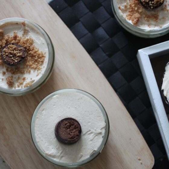 vegan peanut butter cheesecakes in ramekins and a peanut butter easter egg cheesecake on wooden boards