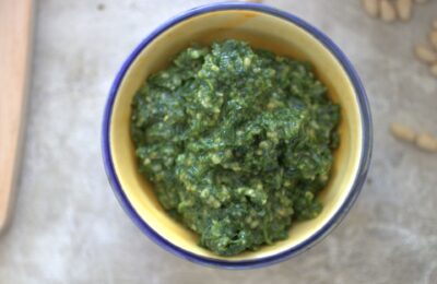 a pot of rocket & basil peso recipe against a grey marl background