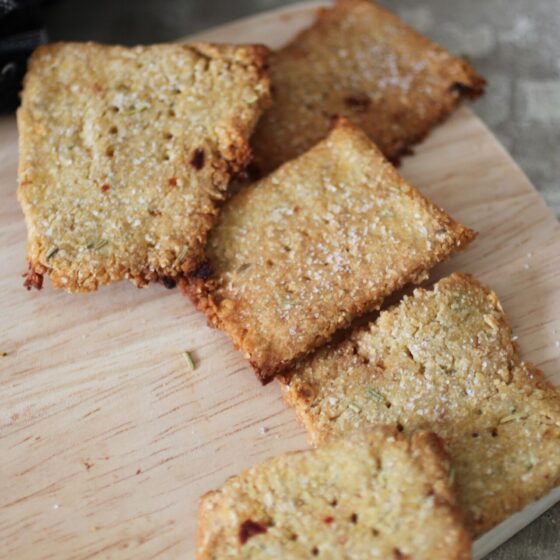 a few chilli and rosemary crackers on the end of a wooden tray