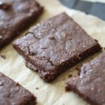 a close up shot of some chocolate crackers on a sheet of baking paper