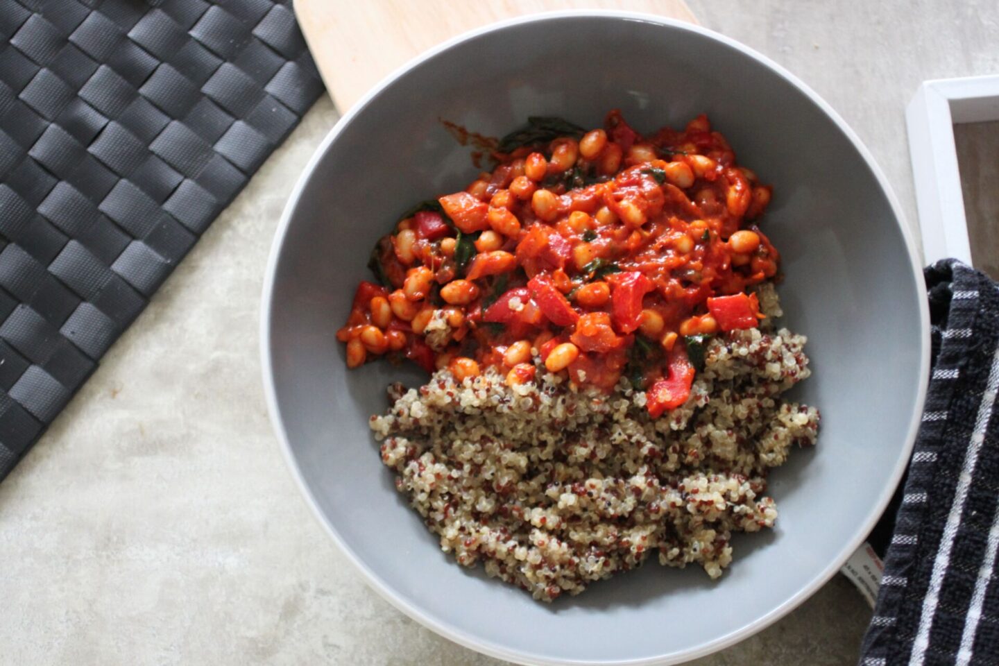 bowl of creamy harissa beans recipe with quinoa on a dining table