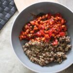 bowl of creamy harissa beans recipe with quinoa on a dining table