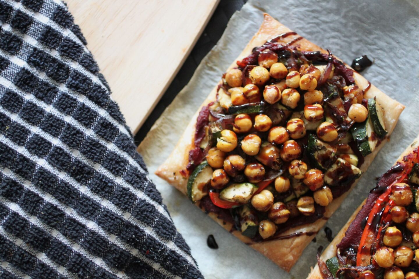 two mediterranean vegetable tarts on a dining table, shot from above